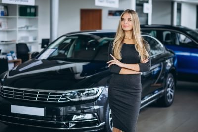 female-sales-person-car-showroom-by-car-scaled.jpg